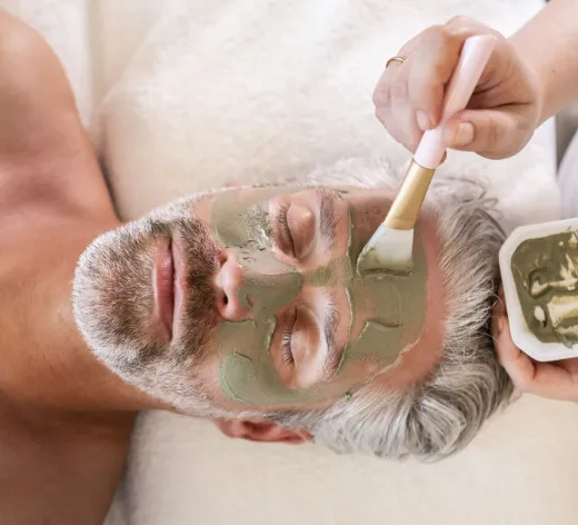 Mann bekommt eine Gesichtsmaske aufgetragen.