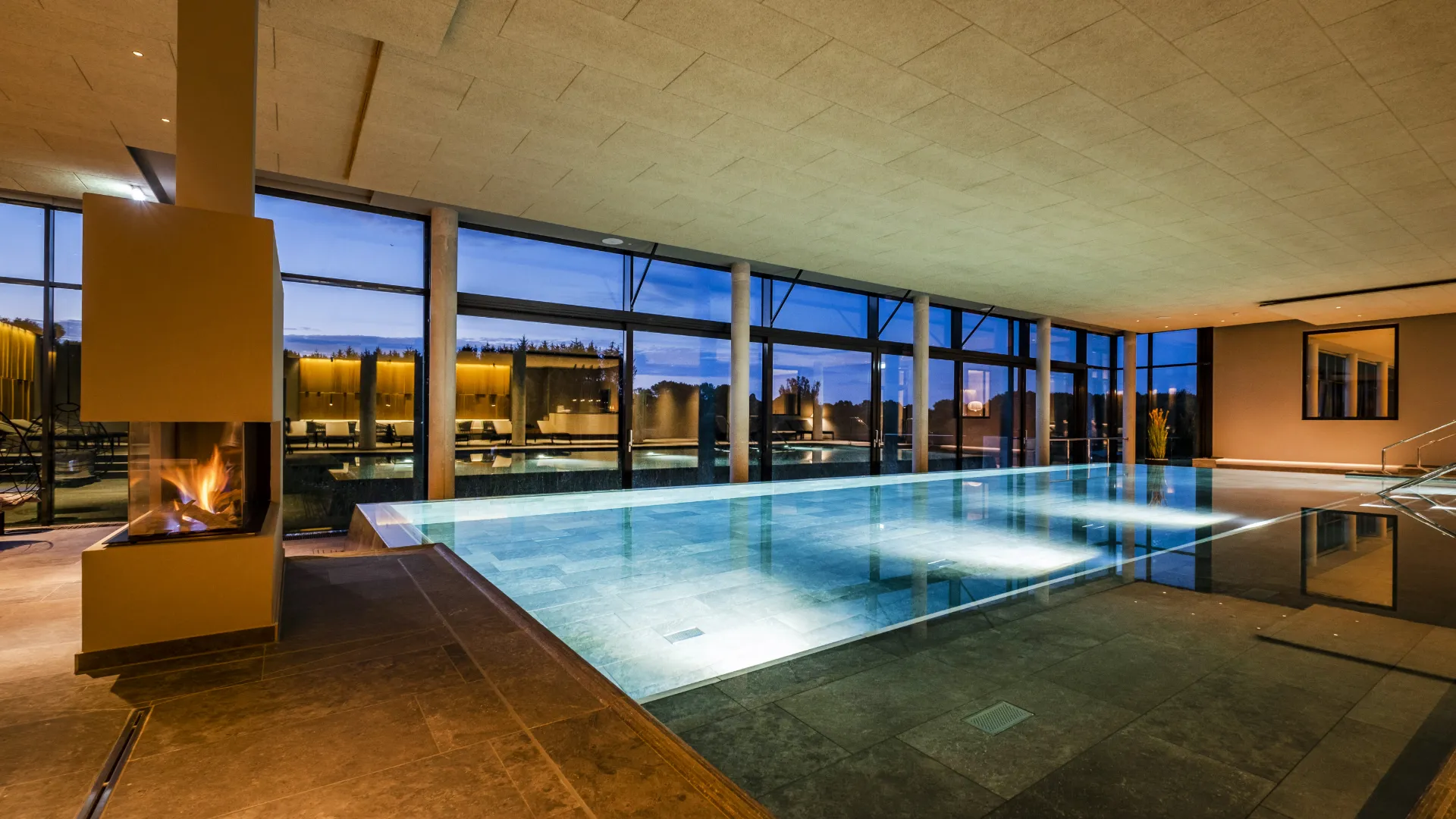 Beleuchteter Pool mit Fensterfront