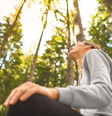 eine Frau sitzt in Wald